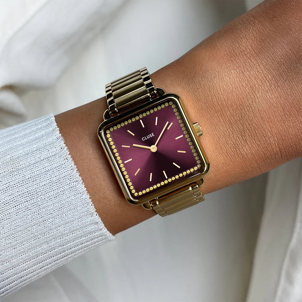 Montre Cluse La Tétragone femme. Boîtier carré doré 28,5 mm, cadran rouge vin serti de pierres dorées et bracelet acier inoxydable 16 mm.