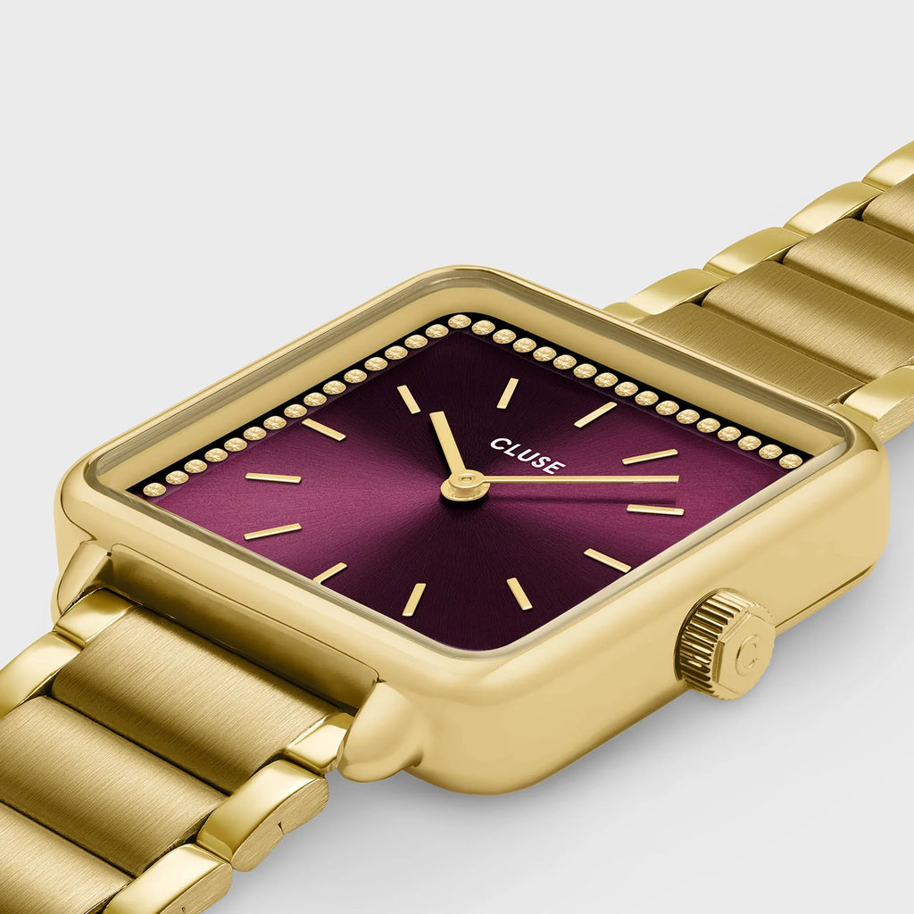 Montre Cluse La Tétragone femme. Boîtier carré doré 28,5 mm, cadran rouge vin serti de pierres dorées et bracelet acier inoxydable 16 mm.